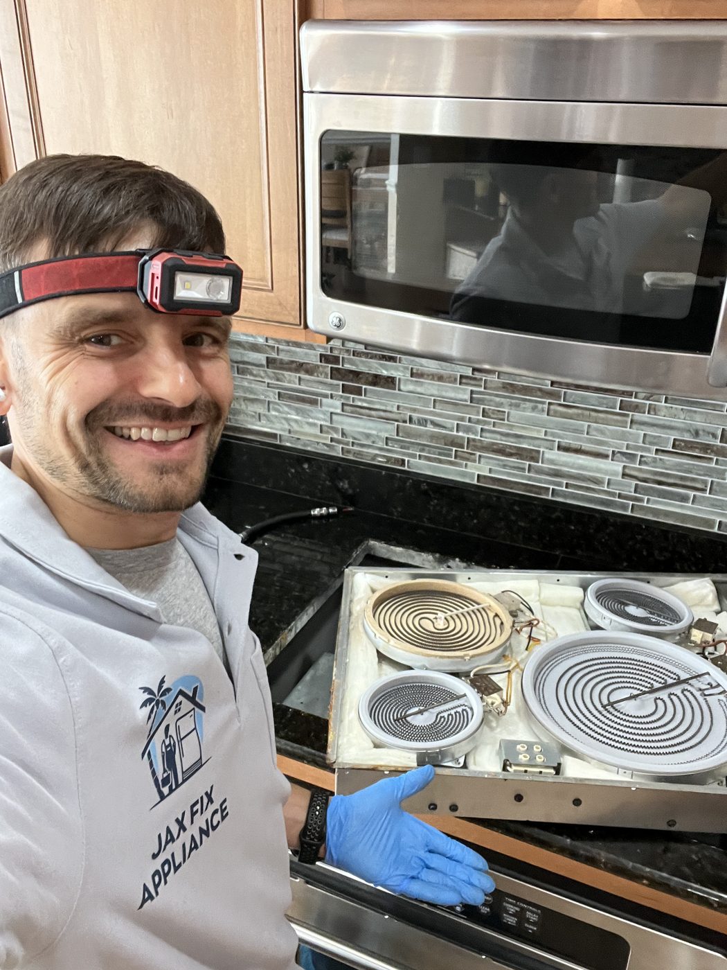 Electric cooktop heating elements exposed for burner replacement