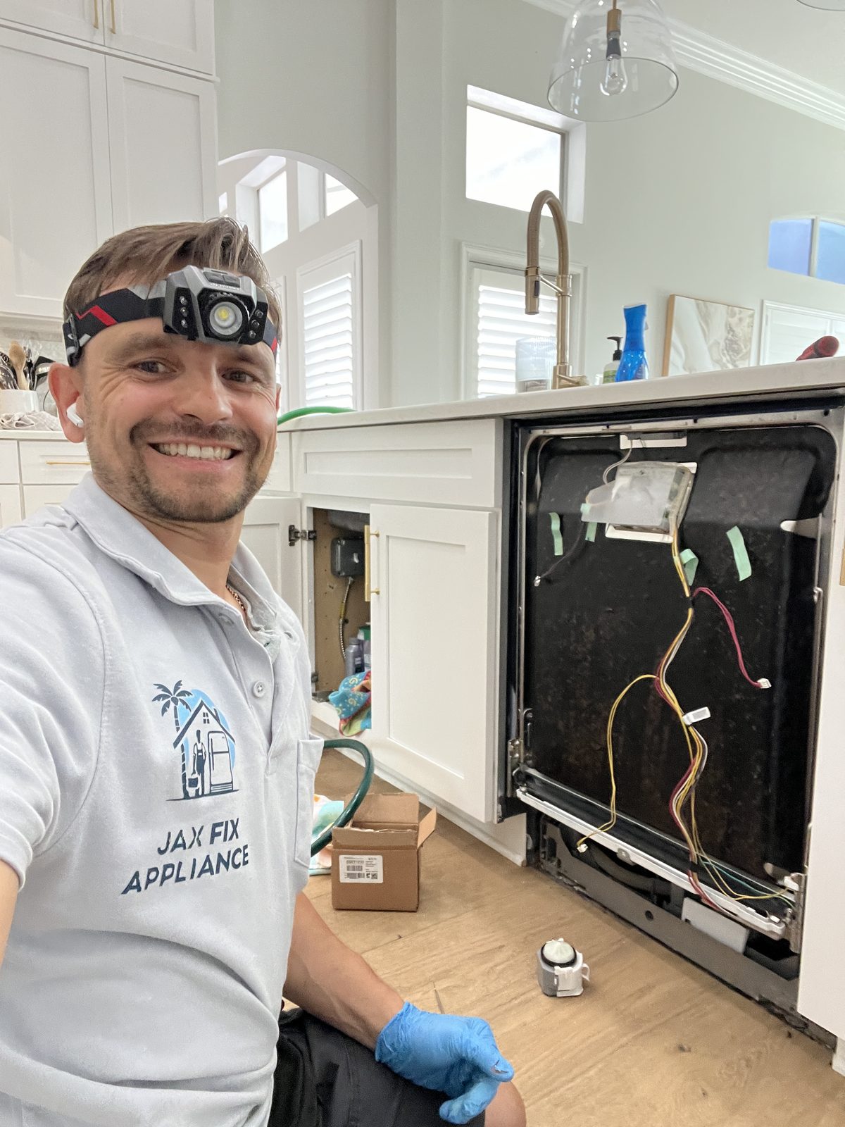 Konstantin at a dishwasher with the door panel open showing wiring during diagnostics