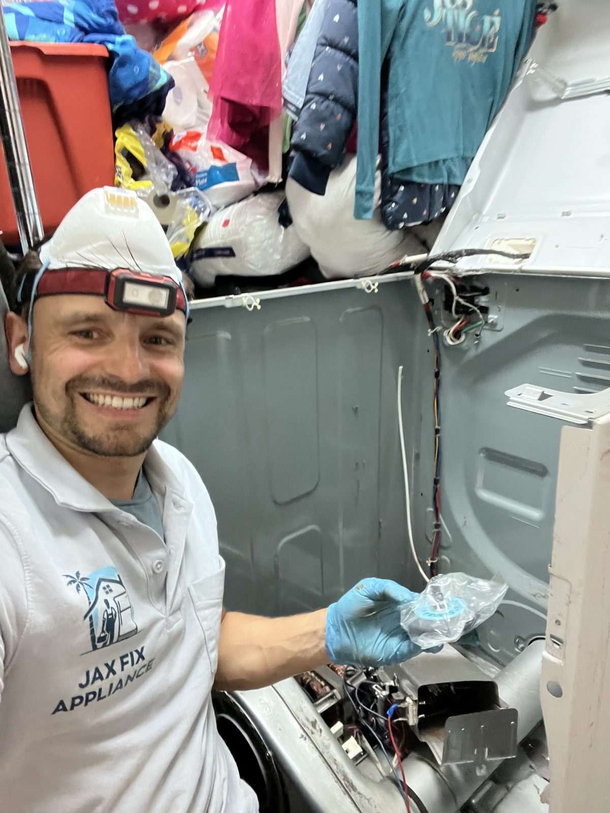 Konstantin installing a new part in an opened dryer cabinet