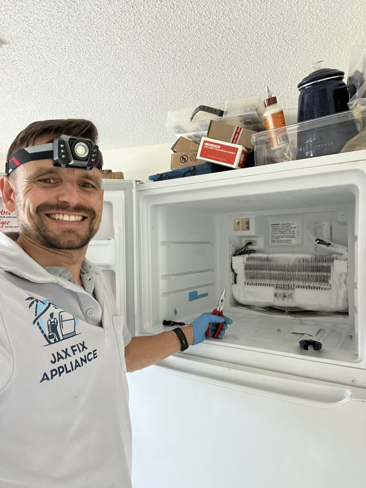 Konstantin servicing the defrost system of a top-freezer refrigerator